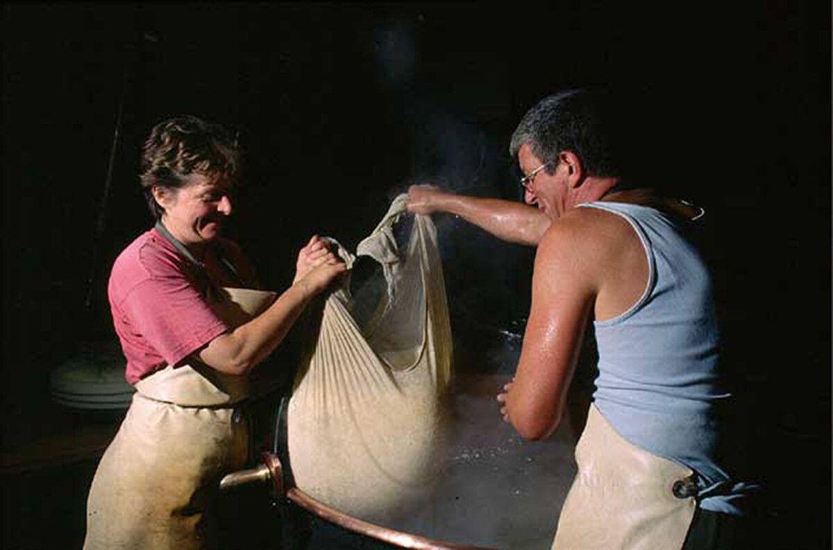 Ein Älplerpaar bei der Produktion des Käses L'Etivaz.